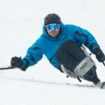 Rich wearing ski gear on a monoski going down a slope