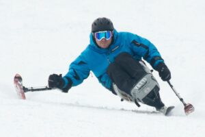 Rich wearing ski gear on a monoski going down a slope